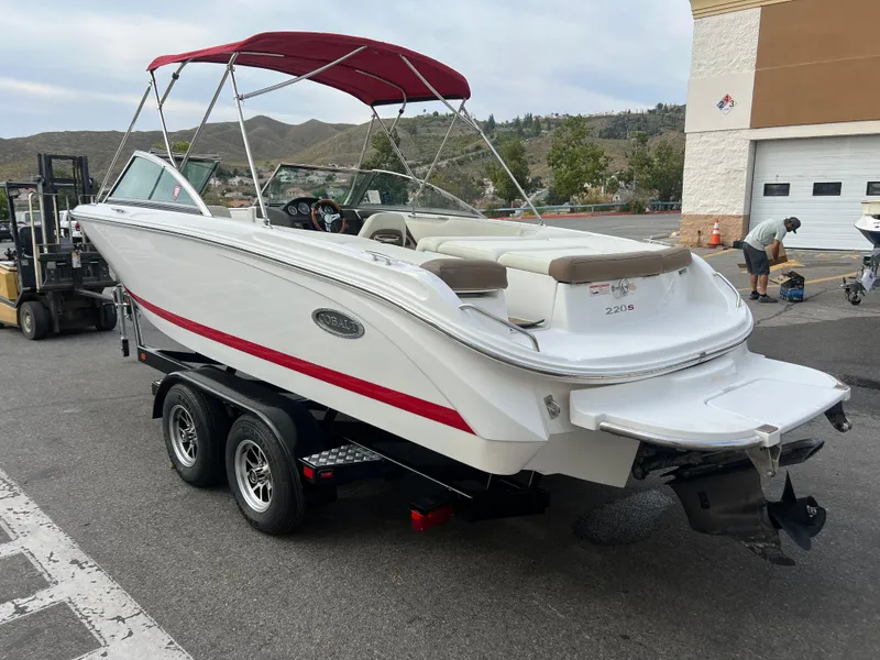 Slide: The Image of 2017 Cobalt 220S boat with red canopy on trailer in parking lot. - 5