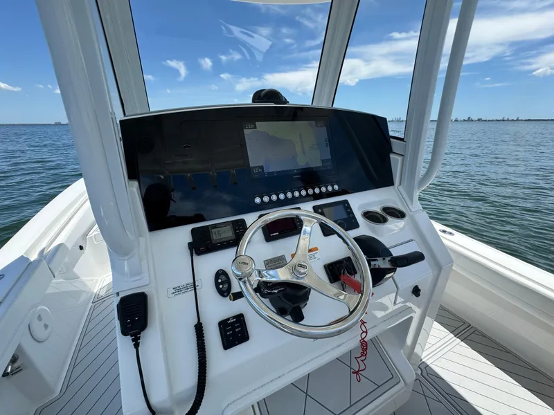 Slide: The Image of 2020 Regulator 26XO boat helm with steering wheel and navigation controls. - 25