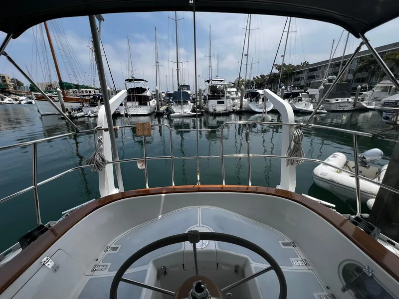 Slide: The Image of Cockpit view from 1987 Norseman 400 sailboat in marina, surrounded by yachts and calm water. - 17