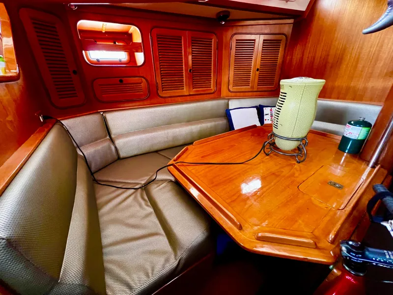 Slide: The Image of Cozy 1987 Norseman 400 yacht interior with wooden table and cushioned seating. - 28