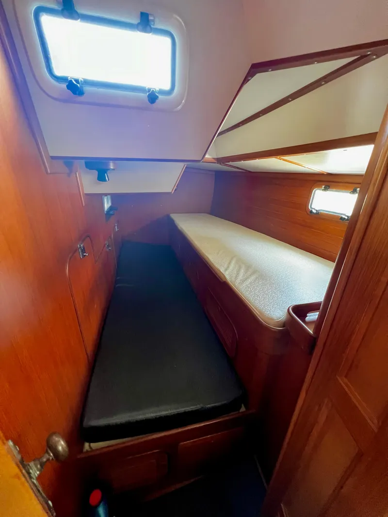 Slide: The Image of Cozy cabin interior of 1987 Norseman 400 sailboat with wooden paneling and twin berths. - 31