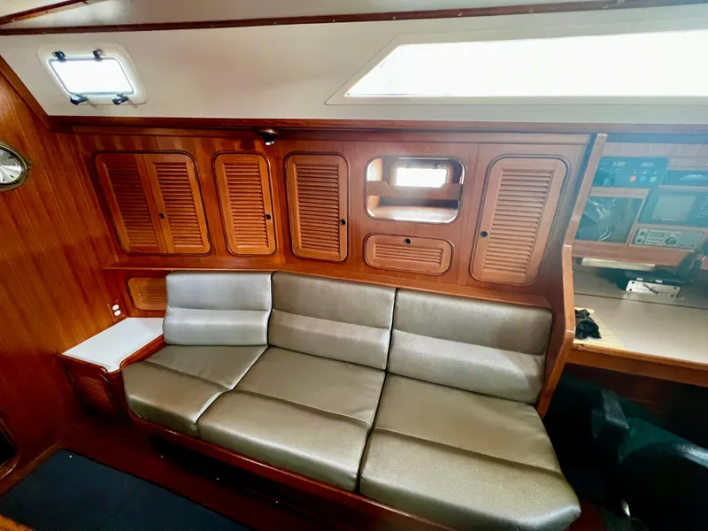 Slide: The Image of 1987 Norseman 400 yacht interior with wooden cabinets and a comfortable gray sofa. - 32