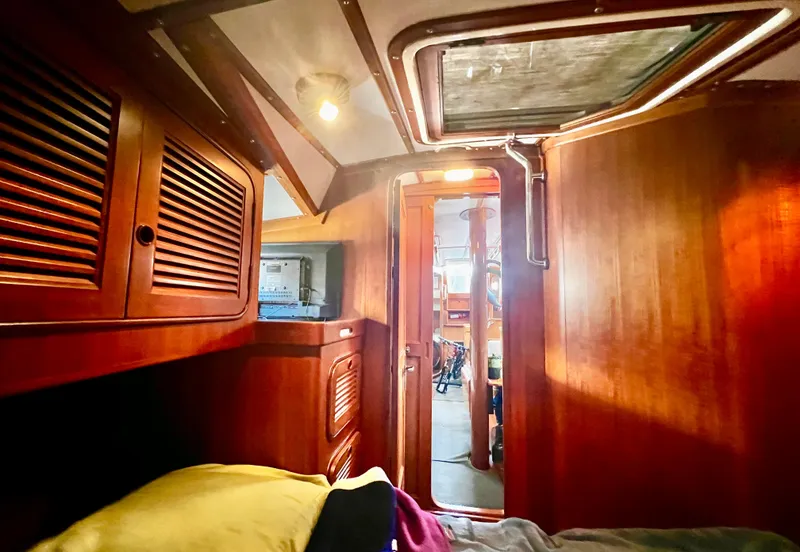 Slide: The Image of Interior of 1987 Norseman 400 sailboat with wooden cabinetry and cozy lighting. - 33