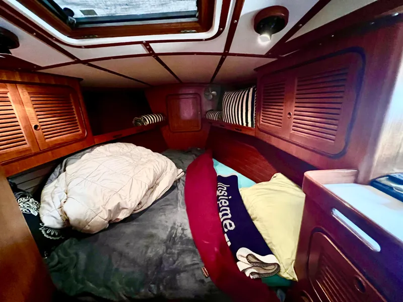 Slide: The Image of Cozy cabin interior of 1987 Norseman 400 sailboat with bedding and wooden storage. - 34
