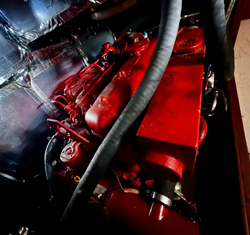 Slide: The Image of Red engine of a 1987 Norseman 400, featuring prominent hoses and metallic surroundings. - 42