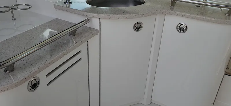 Slide: The Image of 2009 Sea Ray 500 Sundancer yacht interior with sleek white cabinetry and stainless steel sink. - 19