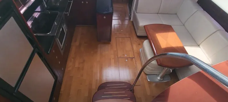 Slide: The Image of Interior of 2009 Sea Ray 500 Sundancer with wood flooring and modern seating area. - 24