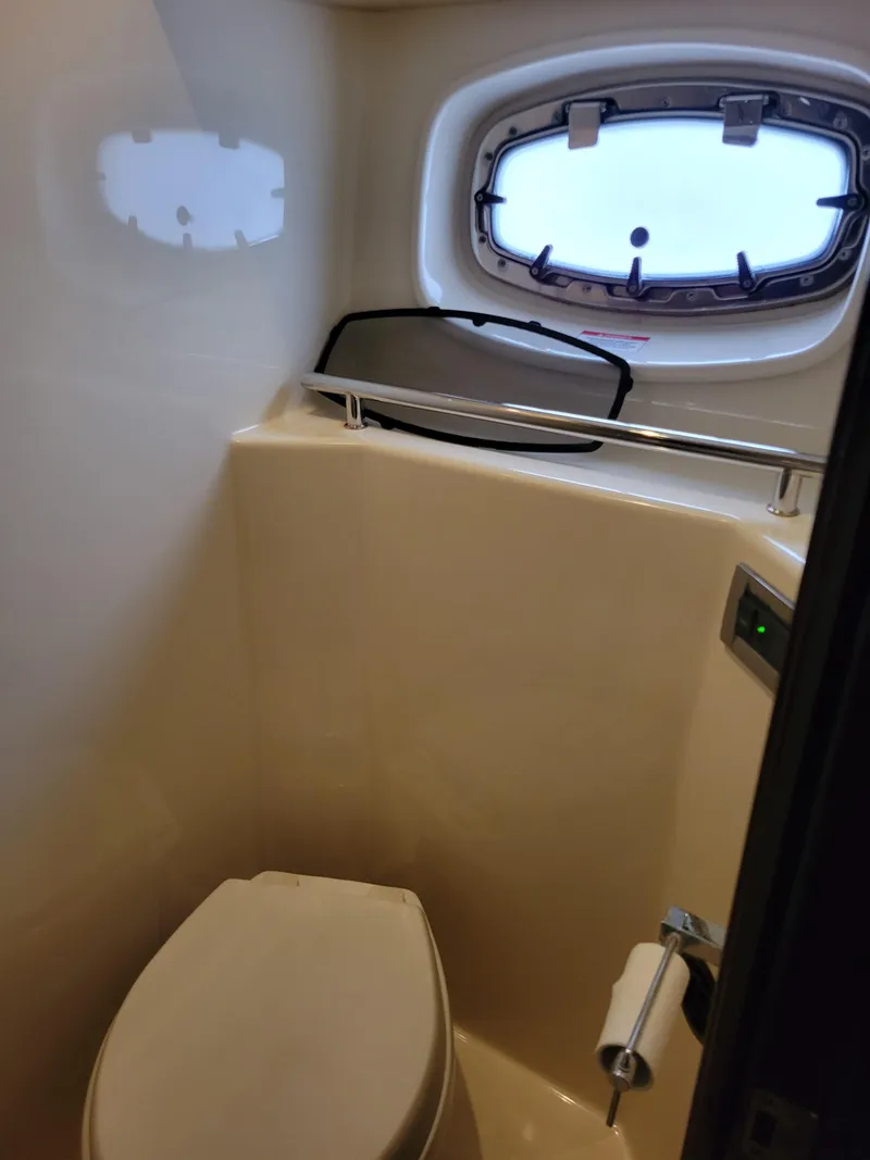 Slide: The Image of 2009 Sea Ray 500 Sundancer bathroom with porthole window and toilet. - 30