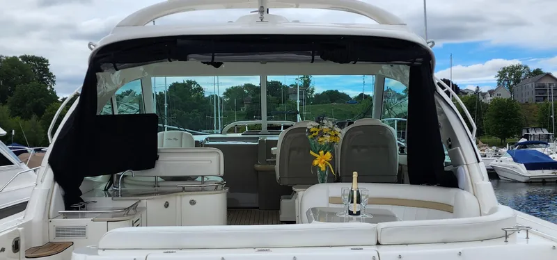 Slide: The Image of 2009 Sea Ray 500 Sundancer yacht with elegant interior and outdoor seating at a marina. - 13