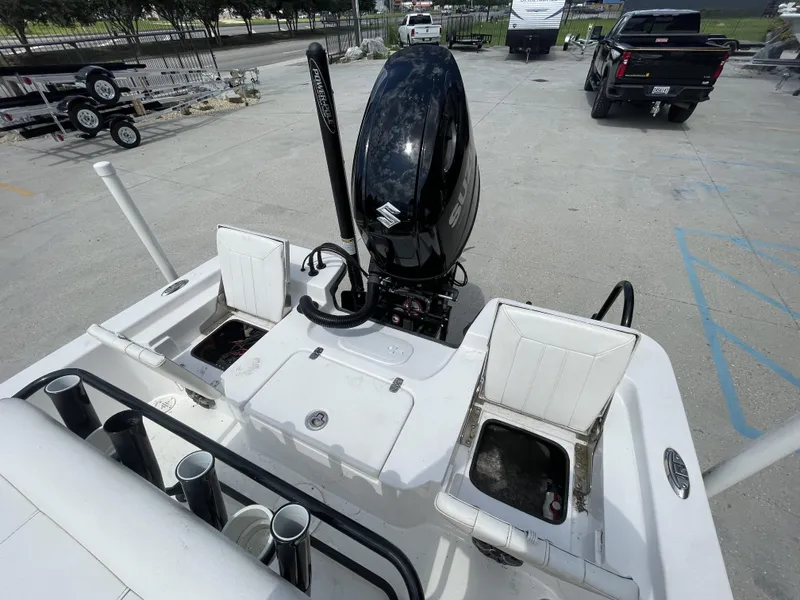 Slide: The Image of Boat with Suzuki outboard motor, rod holders, and storage compartments in a parking lot. - 13