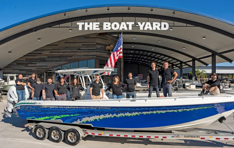 Slide: The Image of Team posing with 2020 Blazer boat at The Boat Yard dealership. - 20