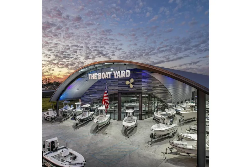 Slide: The Image of The Boat Yard dealership showcasing various boats at sunset. - 21