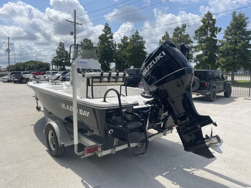 Slide: The Image of 2021 Blazer Bay boat with Suzuki outboard motor on trailer in parking lot. - 22