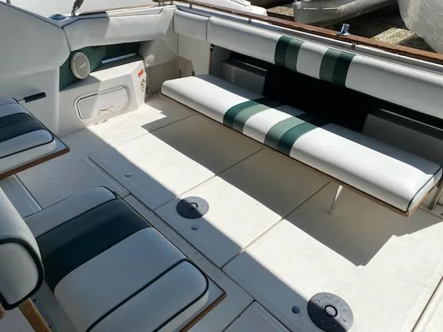 Slide: The Image of 1989 Sea Ray '30 Sundancer boat interior with striped seating and storage compartments. - 4