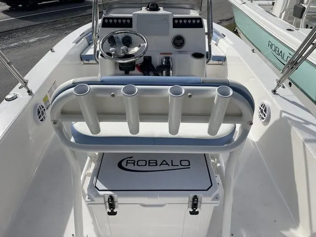 Slide: The Image of 2024 Robalo 206 Cayman boat interior with steering console and rod holders. - 11