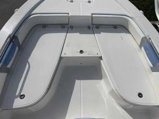 Slide: The Image of 2024 Robalo 206 Cayman boat deck with cushioned seating and storage compartments. - 26