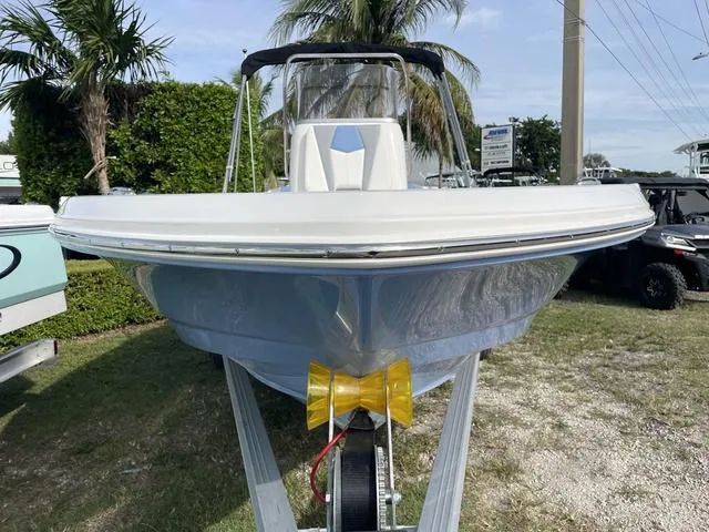 Slide: The Image of 2024 Robalo 206 Cayman boat on trailer, front view, palm trees in background. - 3