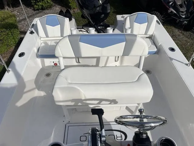Slide: The Image of 2024 Robalo 206 Cayman boat interior with white seating and steering console. - 32