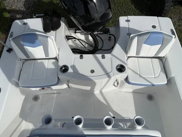 Slide: The Image of 2024 Robalo 206 Cayman boat interior with white seating and rod holders. - 34