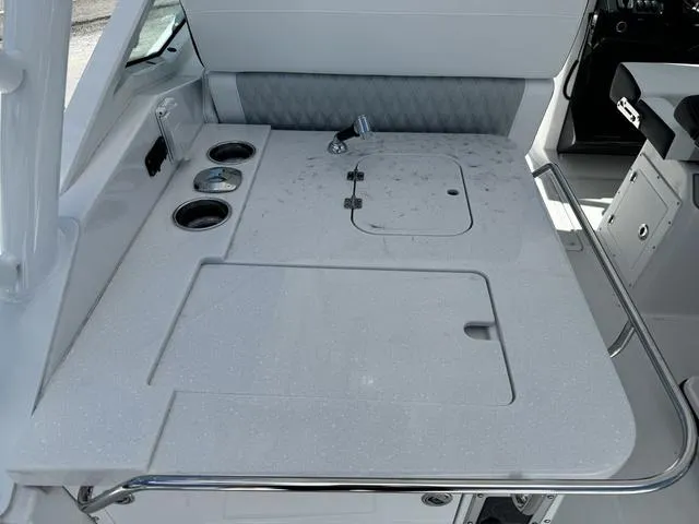 Slide: The Image of 2024 Blackfin 302DC boat interior with a clean, modern workstation and cup holders. - 14