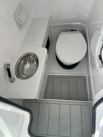 Slide: The Image of 2024 Blackfin 302DC boat interior bathroom with sink and toilet. - 25