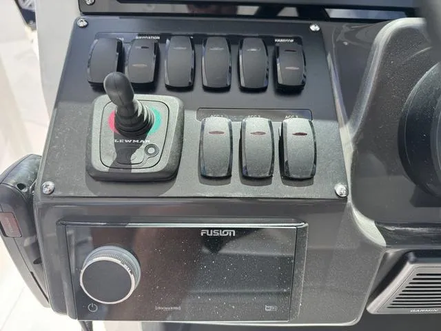 Slide: The Image of Control panel of 2024 Blackfin 302DC boat with Lewmar joystick and Fusion audio system. - 31