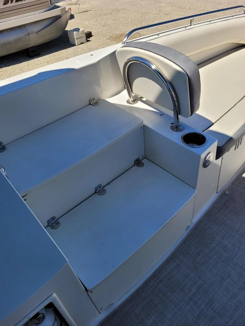 Slide: The Image of Interior seating and steps of a 2022 Stingray 212SC boat with cup holder. - 12