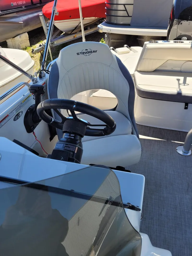 Slide: The Image of 2022 Stingray 212SC boat interior with steering wheel and captain's chair. - 13