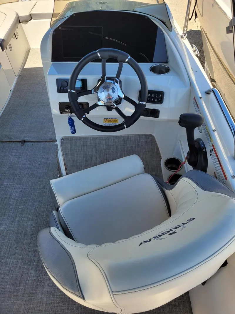Slide: The Image of 2022 Stingray 212SC boat cockpit with steering wheel and captain's chair. - 14