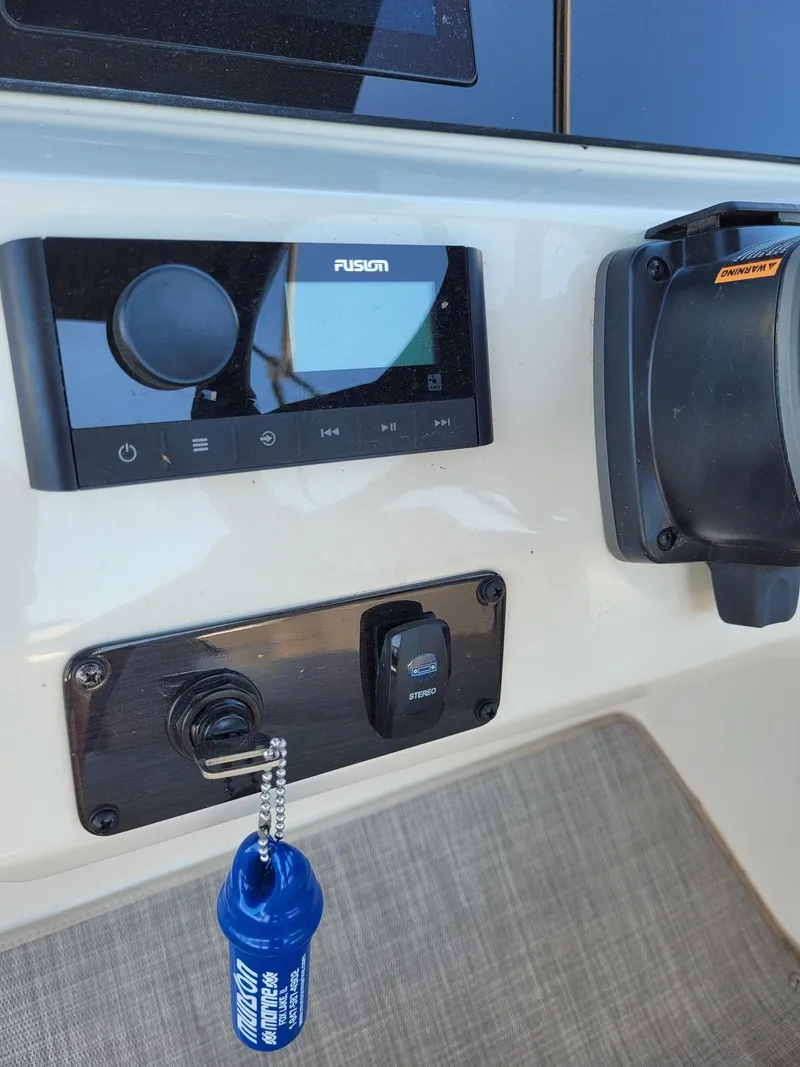 Slide: The Image of Control panel of a 2022 Stingray 212SC boat with Fusion stereo system. - 16