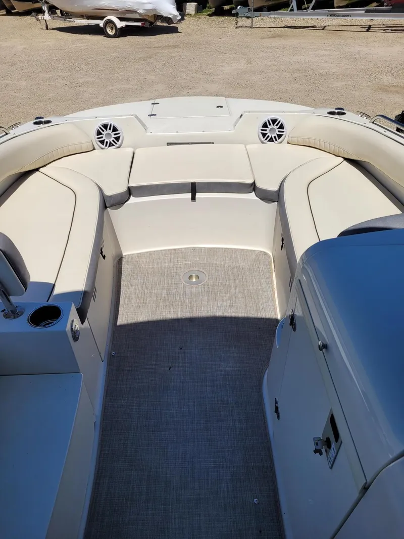 Slide: The Image of Interior of a 2022 Stingray 212SC boat with beige seating and speakers. - 19