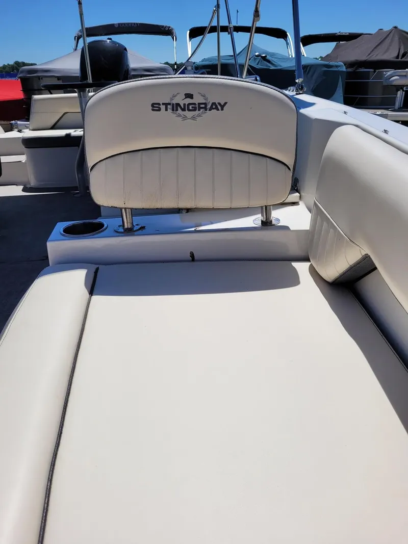Slide: The Image of 2022 Stingray 212SC boat interior with white leather seating. - 24
