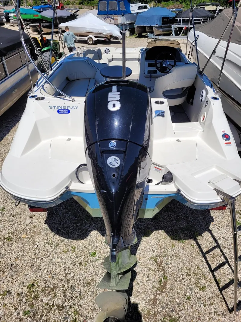 Slide: The Image of 2022 Stingray 212SC boat with a 150 HP outboard motor in a marina. - 4