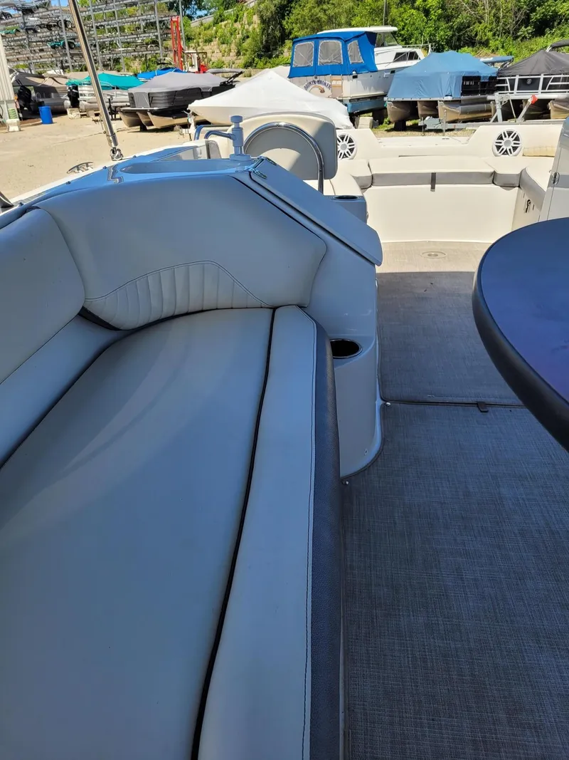 Slide: The Image of 2022 Stingray 212SC boat interior with white seating and outdoor storage. - 8