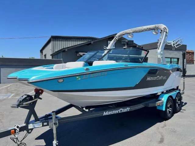 Slide: The Image of 2019 MasterCraft NXT20 boat in blue and white on a trailer. - 2