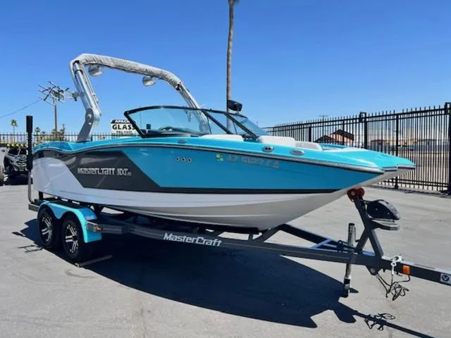 Slide: The Image of 2019 MasterCraft NXT20 boat on trailer, blue and white, parked outdoors. - 4