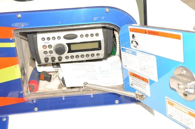 Slide: The Image of Boat radio compartment of a 2009 Concept 27' CC with open hatch and safety notices. - 21