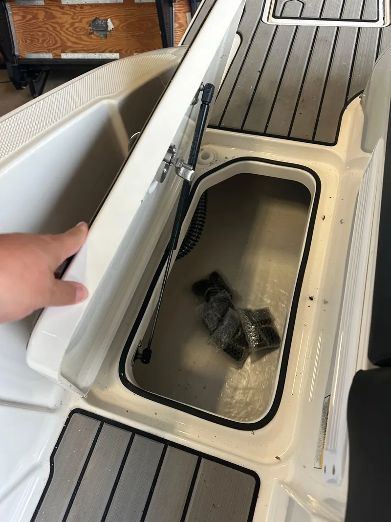 Slide: The Image of 2024 Sea Ray SPX 210 boat storage compartment with open lid. - 10