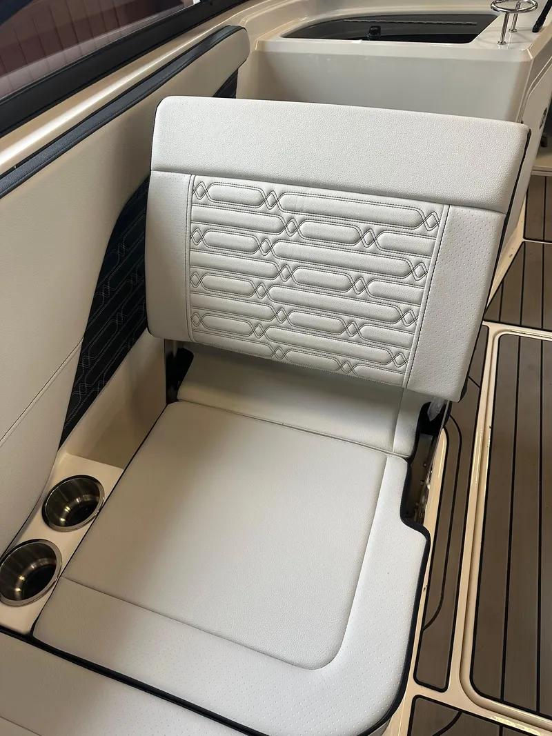 Slide: The Image of 2024 Sea Ray SPX 210 boat interior with white cushioned seating and cup holders. - 22