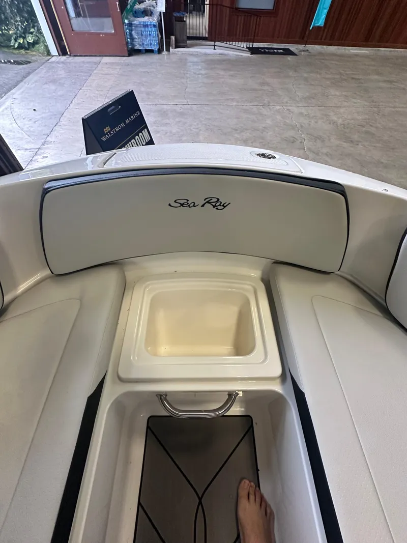 Slide: The Image of 2024 Sea Ray SPX 210 boat interior with seating and storage compartment. - 28