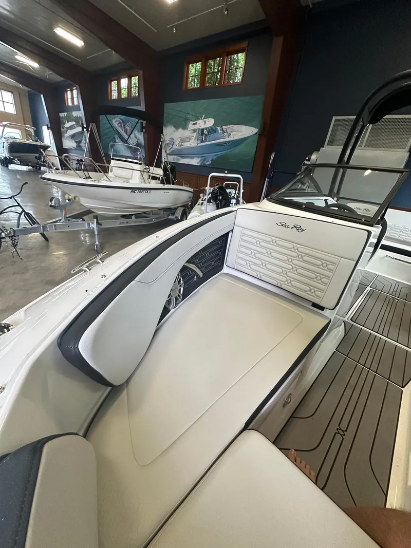 Slide: The Image of 2024 Sea Ray SPX 210 boat interior in showroom, featuring sleek seating and modern design. - 31