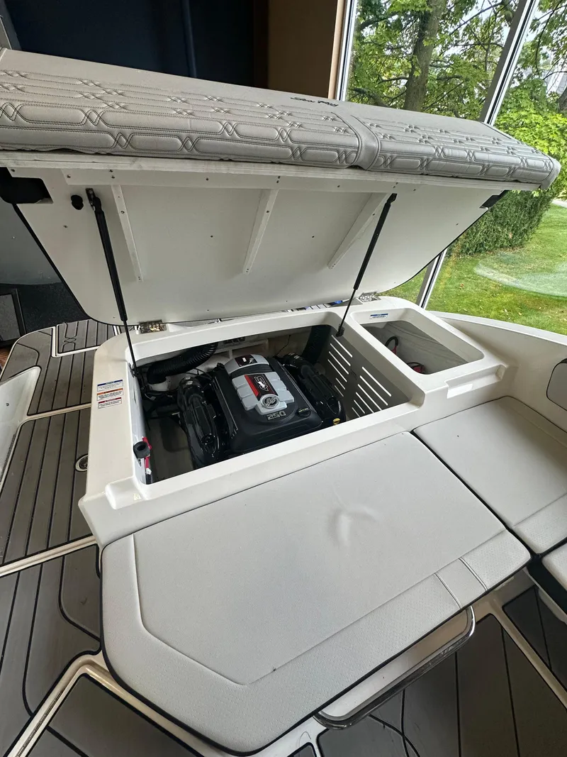 Slide: The Image of 2024 Sea Ray SPX 210 boat engine compartment with open hatch, showcasing interior design. - 5