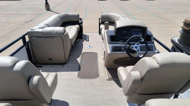 Slide: The Image of 2024 Regency 230 DL3 pontoon boat with powerful outboard motor and ladder, parked outdoors. - 3