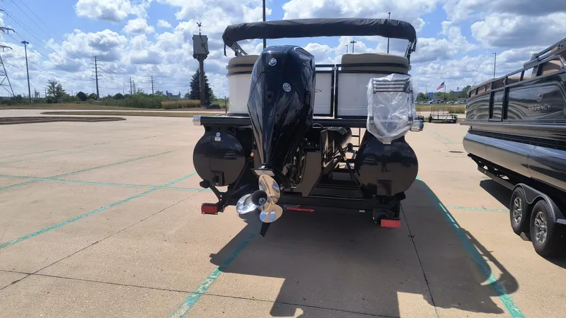 Slide: The Image of 2024 Regency 230 DL3 pontoon boat on trailer, parked outdoors under clear blue sky. - 4