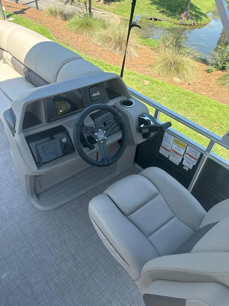 Slide: The Image of 2024 Sun Tracker Party Barge 20 DLX helm with captain's chair and steering wheel. - 7