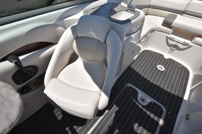 Slide: The Image of 2007 Chaparral 256 SSi boat interior with white captain's chair and black striped flooring. - 9