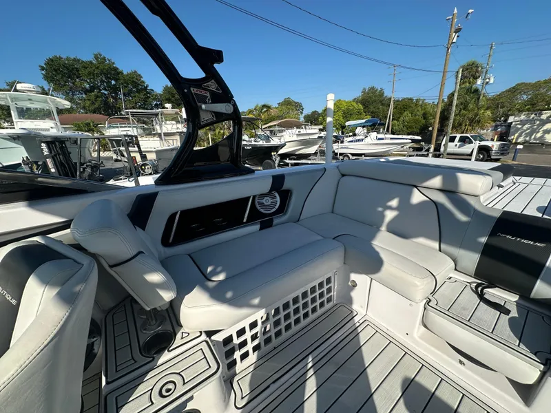 Slide: The Image of 2010 Nautique Super Air Nautique 230 interior with white seating and modern design. - 10
