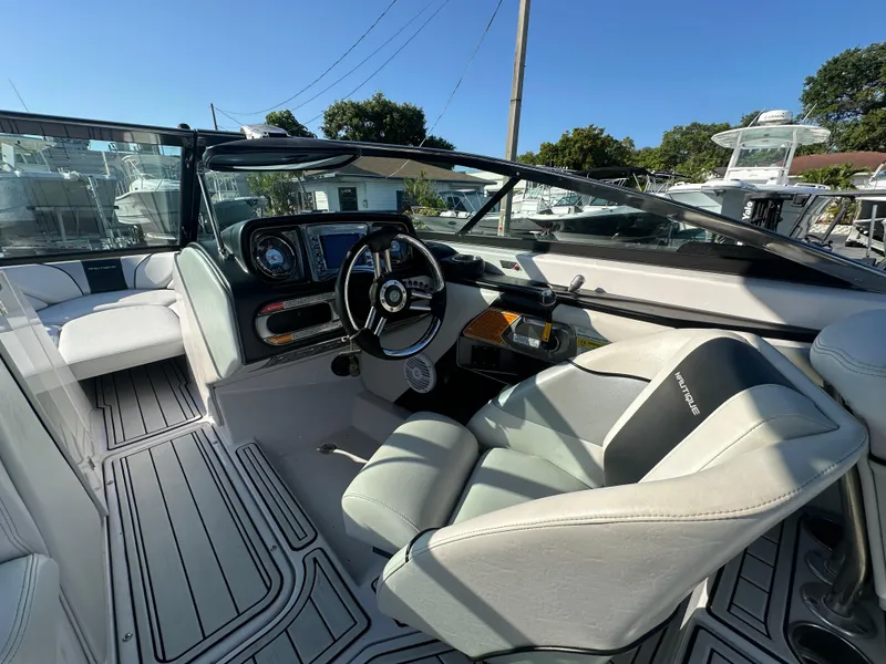Slide: The Image of 2010 Nautique Super Air Nautique 230 boat cockpit with steering wheel and dashboard. - 12