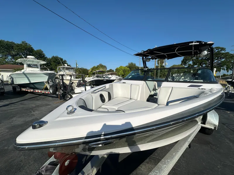 Slide: The Image of 2010 Nautique Super Air Nautique 230 boat on trailer in marina. - 3