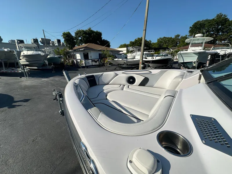 Slide: The Image of 2010 Nautique Super Air Nautique 230 boat with spacious seating in a marina. - 4